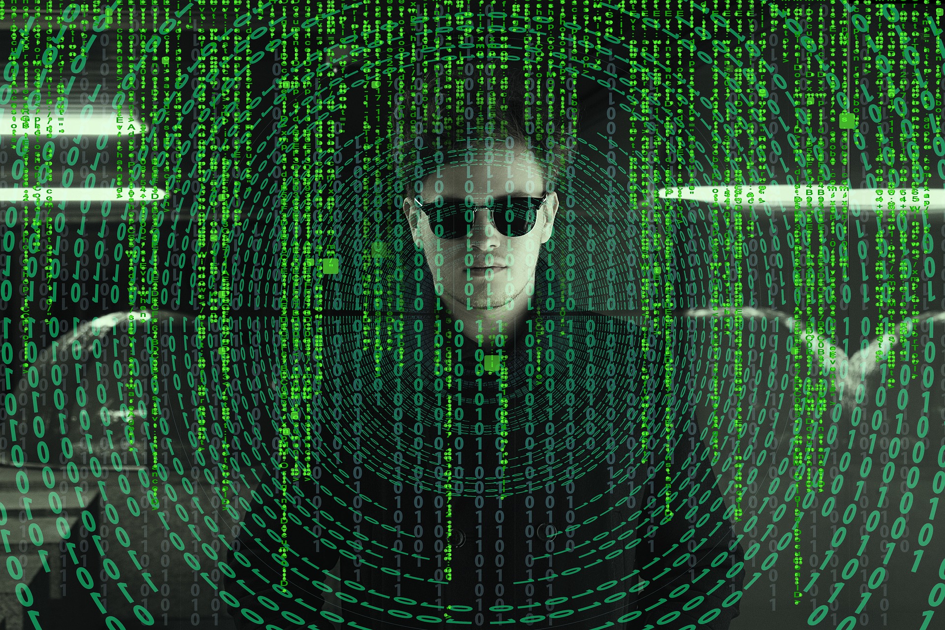 Man in sunglasses with matrix-like numbers on screen